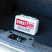 A Medique small vehicle first aid kit in the trunk of a car.