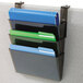 A Deflecto smoke-colored file holder for partition walls with three pockets holding file folders.