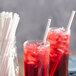 Two glasses of red drink with EcoChoice white paper straws.