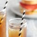 Two glasses of iced tea with EcoChoice black and white striped paper straws on a table.
