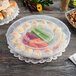 A Fineline plastic tray with 15 slots of eggs and vegetables on a table.