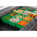 A Tablecraft green cast aluminum container filled with vegetables on a salad bar counter.