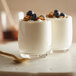 Two glasses of Kronos Fat Free Greek Yogurt with blueberries and granola.