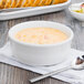 A white Fiesta chowder bowl filled with soup on a table.