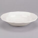 A white bowl with a scalloped edge on a gray background.