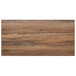 A BFM Seating knotty pine rectangular table top with a dark wood surface.