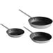 A group of three black Choice aluminum non-stick frying pans with handles.