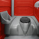A red PolyJohn portable restroom with sink and towel dispenser.