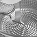 A stainless steel Avancini dough mixer with a spiral pattern on a metal object in a metal bowl.