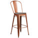 A Flash Furniture copper metal restaurant bar stool with a wood seat.