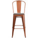 A Flash Furniture copper metal bar stool with a wooden seat.