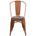 A Flash Furniture copper metal chair with a wood seat.