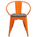 An orange Flash Furniture metal restaurant chair with a wood seat and vertical slat back.
