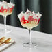A flared Acopa Coupe Glass filled with dessert and a spoon.