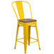 A yellow metal Flash Furniture restaurant bar stool with a wooden seat.