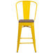 A yellow Flash Furniture restaurant bar stool with a wooden seat and a vertical slat back.