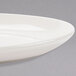 A close up of a Homer Laughlin ivory china platter with a curved edge.