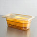 A Carlisle amber plastic food pan with orange slices inside.