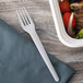 A gray Eco-Products compostable plastic fork next to a salad.
