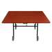 A National Public Seating square cafeteria table with a wood surface and chrome frame.