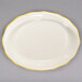 A CAC ivory china platter with scalloped edges and gold trim.