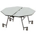 A National Public Seating octagonal cafeteria table with a white ProtectEdge surface and wheels.