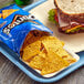 A blue tray with a sandwich and a bag of Doritos Cool Ranch chips.