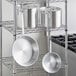 A metal rack with Choice Aluminum pots and pans on it.