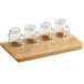 An Acopa Natural wood tray with four mini drinking jars with handles on it.