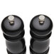 A Chef Specialties Salem Ebony black pepper mill and salt mill with silver knobs on a counter.