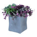 A close-up of a Commercial Zone ModTec gunmetal gray square planter with purple and green plants inside.