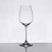 A Spiegelau white wine glass on a reflective surface.