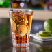A Spiegelau highball glass filled with ice tea and lime slices.