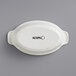 A white oval shaped Acopa stoneware casserole dish with black text.