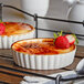 Two Acopa stoneware souffle dishes with dessert and strawberries.