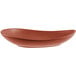 A brown organic porcelain coupe plate with a red rim.
