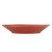 A Libbey round barn red porcelain bowl with a small design on it.