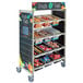 A Cambro Camshelving cart with "Fresh & Fast" merchandiser graphics filled with different types of food.