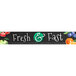 A white sign with a black border and white and green text that says "Fresh & Fast" with fruit.