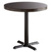 A Lancaster Table & Seating round table with a wood top and black base plate.
