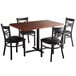 A Lancaster Table & Seating mahogany wood butcher block dining table with black chairs.
