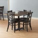 A Lancaster Table and Seating butcher block dining table with 4 chairs in a dining area.