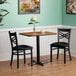 A Lancaster Table & Seating dining set with a cup on the table and two chairs.