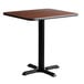 A Lancaster Table & Seating square table with a black base and a brown top.