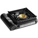 A black Sterno portable gas range with a gold circle on top.