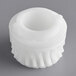A white plastic gear with a hole in it.