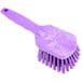 A Carlisle Sparta purple pot scrub brush with a handle.