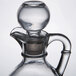 A clear glass Libbey cruet with a handle and stopper.