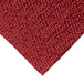 A close-up of a red woven fabric rectangle with a pattern.