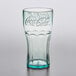 A close up of a clear GET plastic soda glass with a jade Coca-Cola logo.